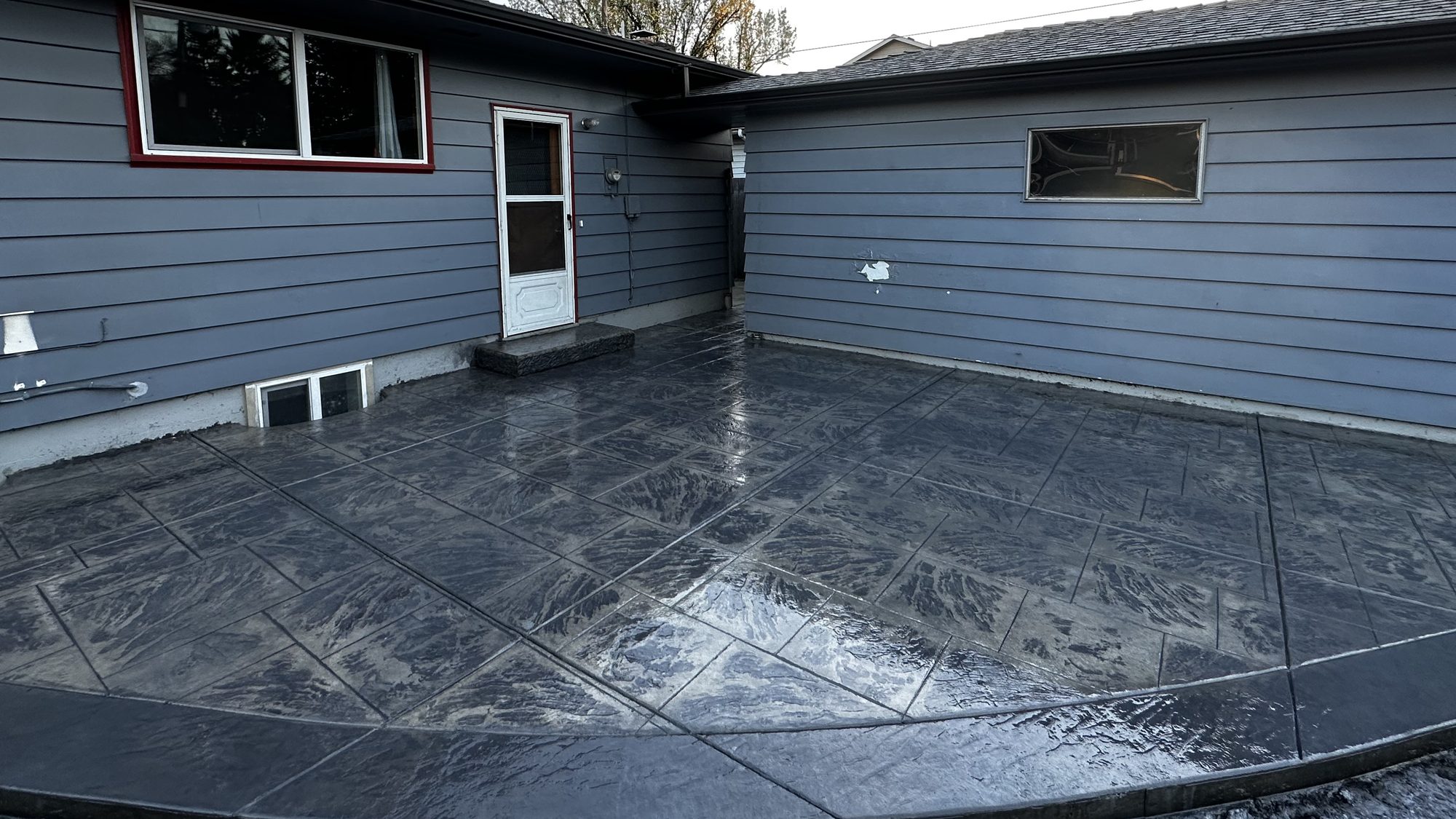 Stamped concrete patio with curved decorative border, completed project by Rocky Ridge Concrete